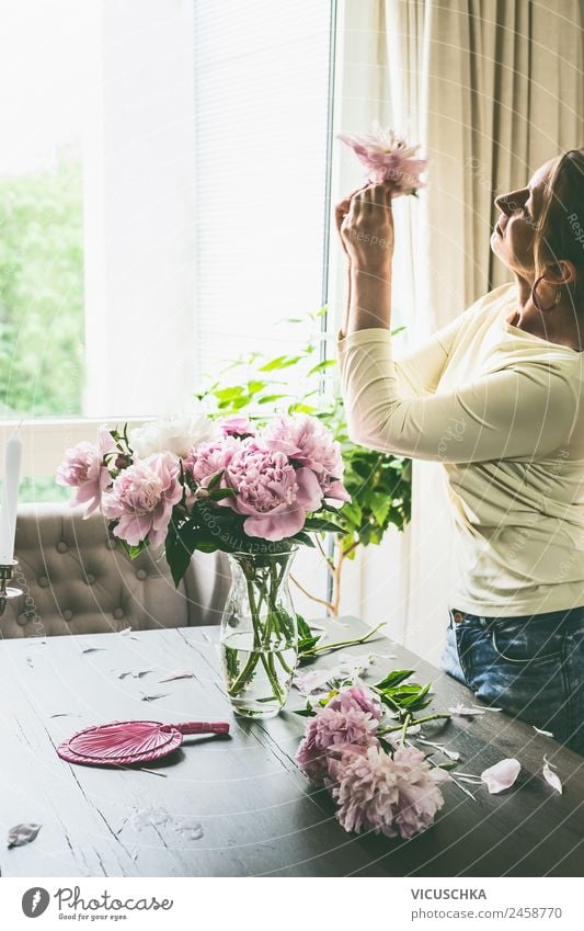 Frau mit Pfingstrosen auf Tisch im Wohnzimmer Lifestyle Design Sommer Häusliches Leben Wohnung Traumhaus Garten Innenarchitektur Mensch Erwachsene Blume