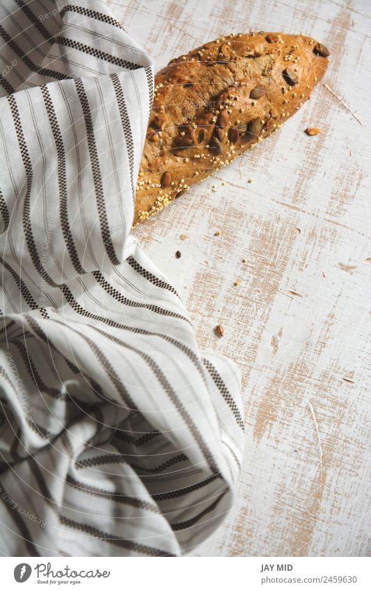 rustikales Brot, umhüllt von gestreiftem Stoff Lebensmittel Frühstück Bioprodukte Diät Menschengruppe frisch braun weiß Tradition Brote Brotlaib Mais Samenbrot