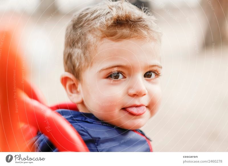 Kleiner süßer Junge, der auf die Kamera schaut und seine Zunge herausstreckt. Freude Glück Gesicht Kind Baby Mund Freundlichkeit lustig neu niedlich verrückt