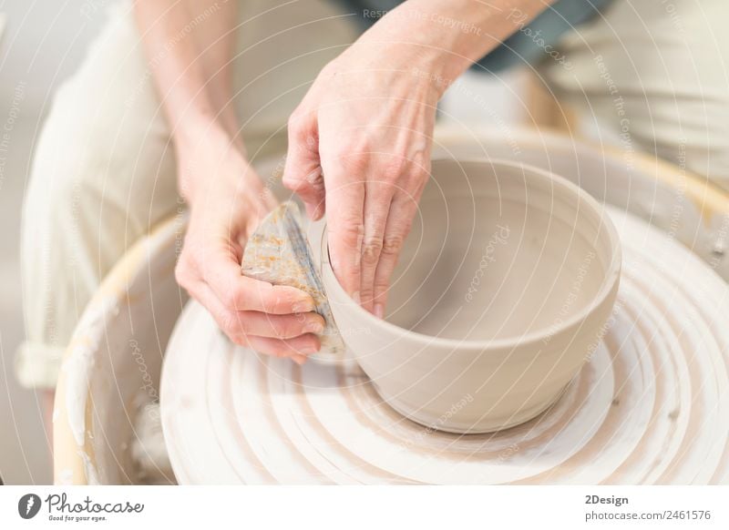 Junge Frau sitzt am Tisch und stellt Ton- oder Keramikbecher her. Geschirr Freizeit & Hobby Handarbeit Arbeit & Erwerbstätigkeit Beruf Handwerker Arbeitsplatz