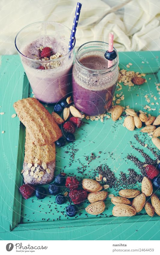 Gesundes Frühstück mit Smoothies, Beeren und Getreide Lebensmittel Frucht Teigwaren Backwaren Himbeeren Blaubeeren Mandel Chia Haferflocken Plätzchen