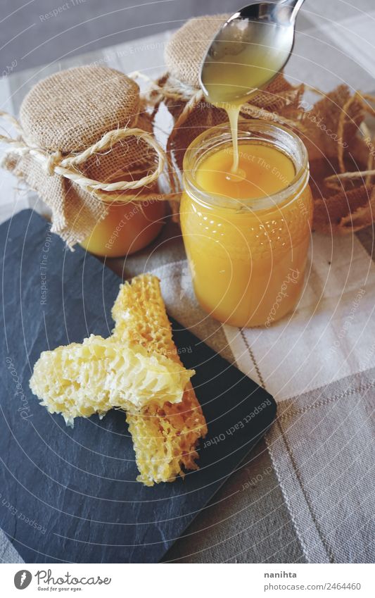 Handwerklicher Honig und Wabenkörper Lebensmittel Süßwaren Bienenwaben Ernährung Essen Bioprodukte Vegetarische Ernährung Glas Löffel authentisch frisch