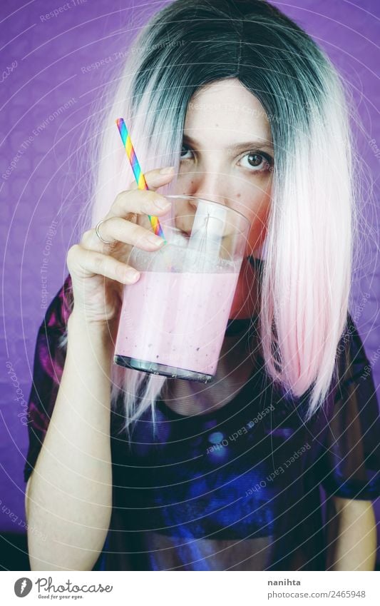 Junge, fitte Frau, die einen rosa Smoothie trinkt. Frucht Getränk trinken Erfrischungsgetränk Saft Milch Milchshake Glas Lifestyle Stil Design Haare & Frisuren