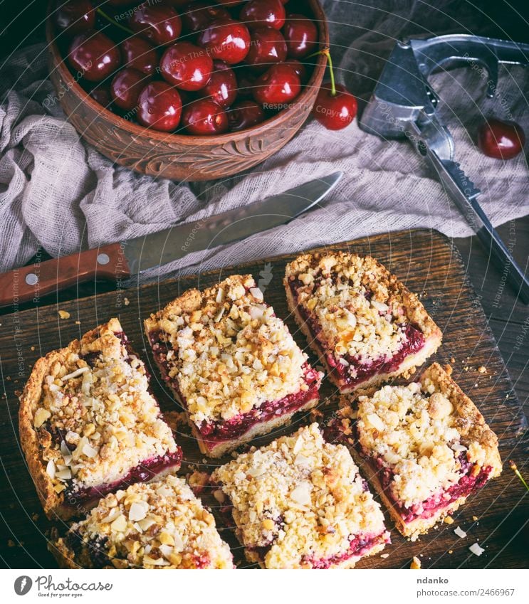 quadratische Kuchenstücke zerbröckeln mit Kirsche Frucht Dessert Süßwaren Vegetarische Ernährung Tisch Holz frisch lecker oben braun gelb rot Pasteten Backwaren