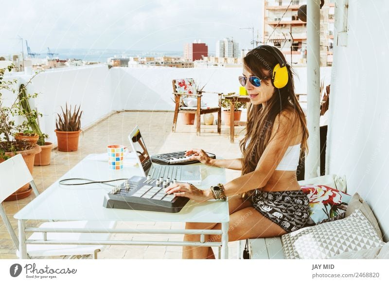 Frau sitzend mit Mischpult, Musikproduktion Lifestyle Sommer Tisch Diskjockey Headset Computer Notebook Tastatur Technik & Technologie feminin Erwachsene Hand 1