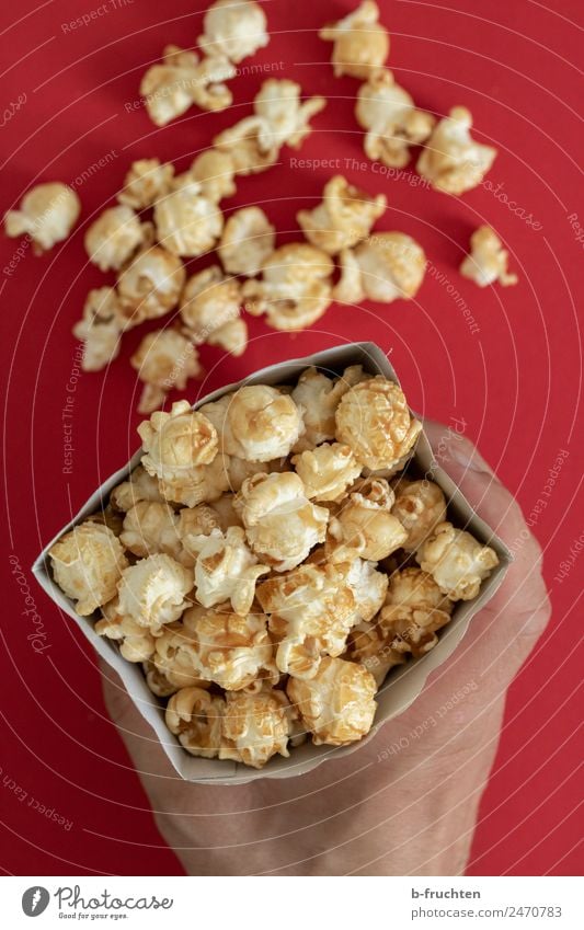 Popcorn in der Tüte Süßwaren Feste & Feiern Mann Erwachsene Hand Essen festhalten Fröhlichkeit Popkorn Kino Mais süß Farbfoto Innenaufnahme Studioaufnahme