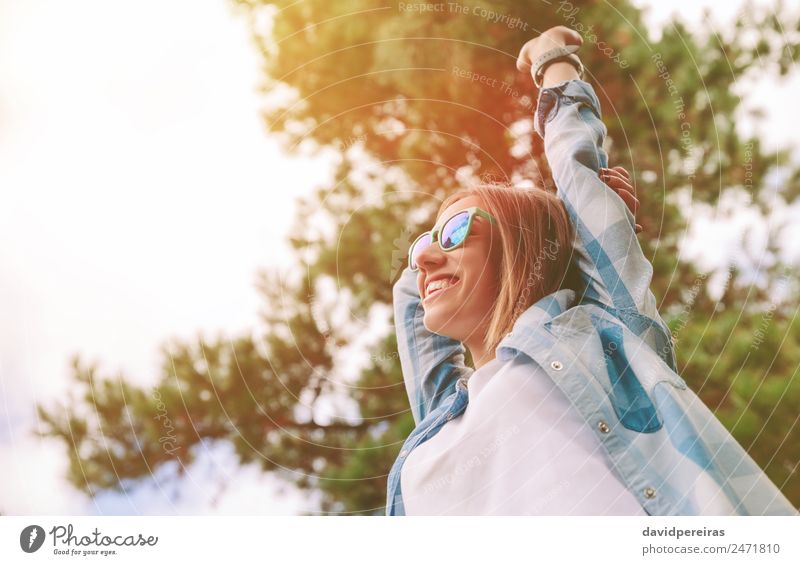 Frau mit Sonnenbrille, die ihre Arme über den Naturhintergrund hebt. Lifestyle Freude Glück Erholung Freizeit & Hobby Freiheit Sommer Erfolg Mensch Erwachsene