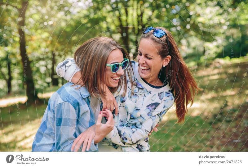 Glückliche Frauen, die sich umarmen und über den Naturhintergrund lachen. Lifestyle Freude schön Freizeit & Hobby Sommer Mensch Erwachsene Freundschaft Paar