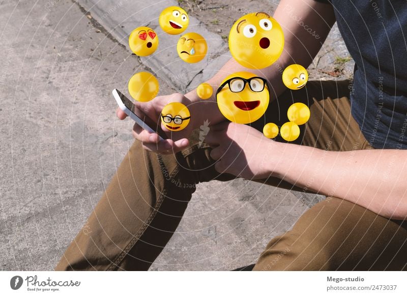 Mann, der ein Smartphone benutzt, das Emojis sendet. Lifestyle Glück Gesicht Telefon PDA Bildschirm Technik & Technologie Internet Mensch Erwachsene Hand lustig