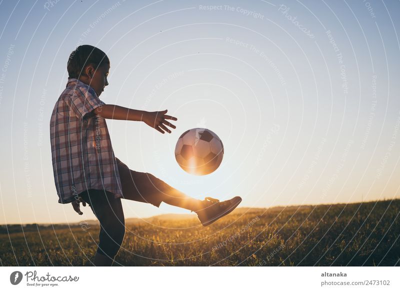 Kleiner Junge spielt auf dem Feld mit einem Fussball. Begriff des Sports. Lifestyle Freude Glück Erholung Freizeit & Hobby Spielen Sommer Fußball Kind Mensch