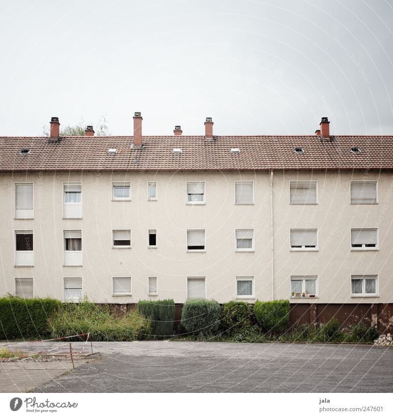 wohnblock Himmel Sträucher Haus Platz Bauwerk Gebäude Mauer Wand Fassade Fenster Tür Schornstein trist Farbfoto Außenaufnahme Menschenleer Textfreiraum oben Tag