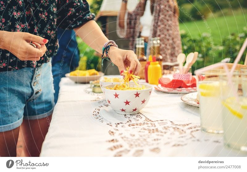 Frau Hand nimmt Pommes frites Kartoffeln aus der Schüssel Brot Limonade Alkohol Bier Teller Schalen & Schüsseln Lifestyle Freude Freizeit & Hobby Sommer Garten