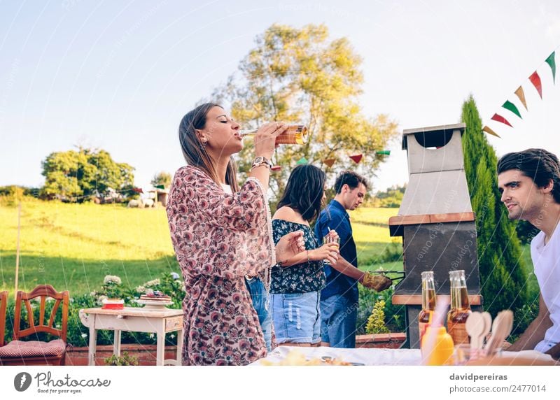 Frau beim Biertrinken im Grill mit Freunden Fleisch Mittagessen Alkohol Flasche Lifestyle Freude Glück Freizeit & Hobby Sommer Garten Tisch sprechen Erwachsene