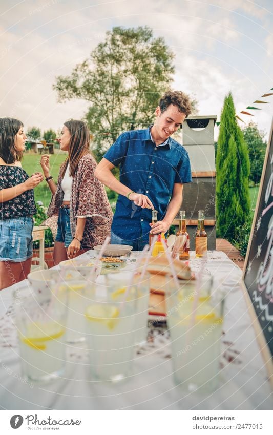 Mann öffnet Bierflasche am Sommergrill Essen Mittagessen Limonade Alkohol Flasche Trinkhalm Lifestyle Freude Glück Freizeit & Hobby Garten Tisch sprechen Frau