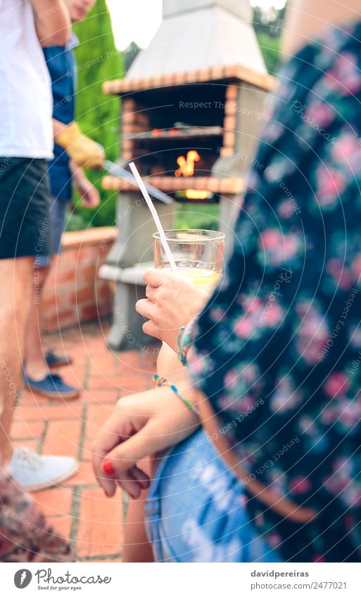 Frau mit Limonadenglas und Freunden beim Kochen im Grill Wurstwaren Mittagessen Lifestyle Freude Glück Erholung Freizeit & Hobby Sommer Garten sprechen