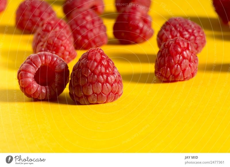 Frische Himbeeren auf gelbem Hintergrund Lebensmittel Frucht Dessert Ernährung Bioprodukte Vegetarische Ernährung Diät Gesunde Ernährung Sommer Natur frisch