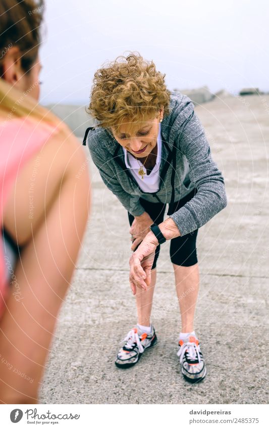 Seniorenfrau mit schicker Uhr und weiblichem Coach Freizeit & Hobby Sport Joggen Bildschirm Mensch Frau Erwachsene alt beobachten Fitness authentisch klug