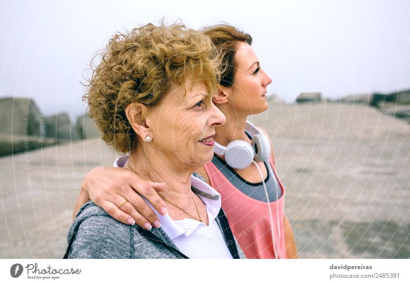 Ältere und junge Sportlerinnen schauen weg. Lifestyle Freizeit & Hobby Meer Mensch Frau Erwachsene Mutter Nebel Beton alt Fitness Liebe sportlich authentisch