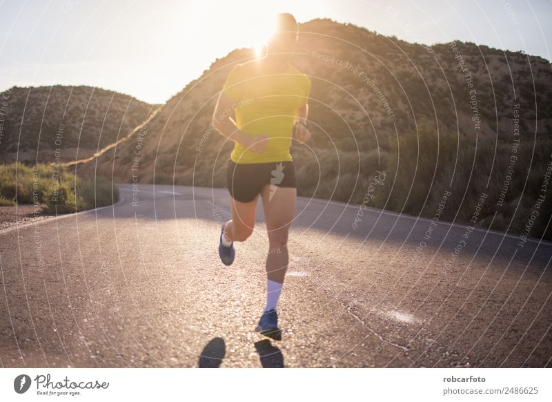 Junger Mann läuft mit grünlich-gelbem Hemd. Lifestyle Sonne Sport Joggen Mensch Erwachsene Park Brücke Bewegung Fitness sportlich Geschwindigkeit weiß rennen