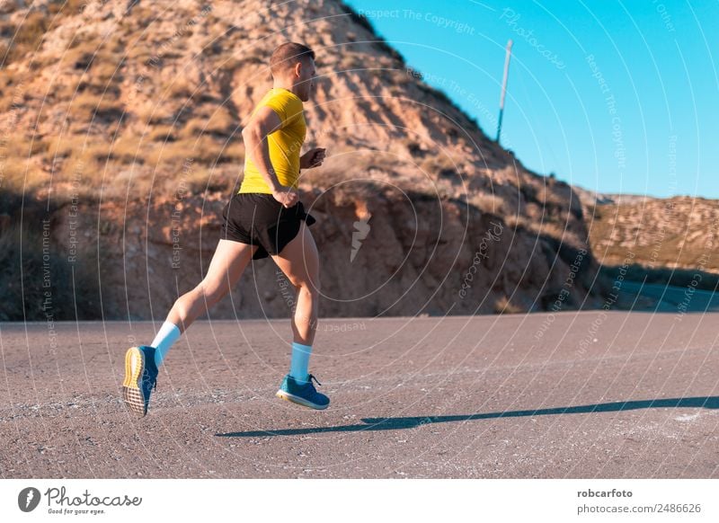 Junger Mann läuft mit grünlich-gelbem Hemd. Lifestyle Sonne Sport Joggen Mensch Erwachsene Park Brücke Bewegung Fitness sportlich Geschwindigkeit weiß rennen