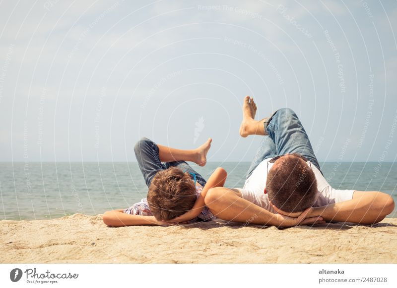 Vater und Sohn spielen zur Tageszeit am Strand. Die Menschen haben Spaß im Freien. Konzept des Sommerurlaubs und der freundlichen Familie. Lifestyle Freude