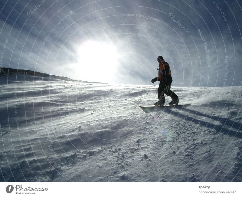 Boarder Snowboard Ferien & Urlaub & Reisen Sport Schnee Berge u. Gebirge Sonne Freude Funsport abwärts Wintersonne Gegenlicht Berghang Schwung steil Wind kalt 1