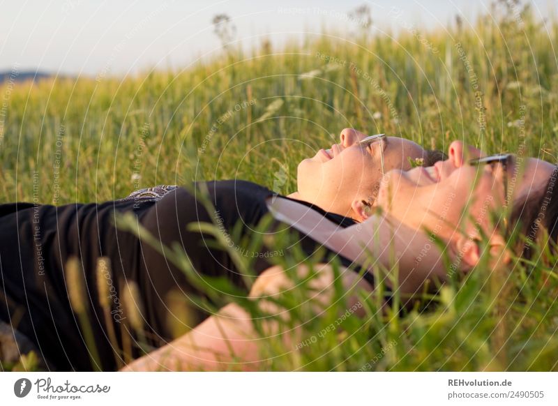 2 Frauen liegen auf einer Wiese Glück frei Zusammensein Lebensfreude Nahaufnahme Lächeln genießen Schönes Wetter Sommer Landschaft Schwester Geschwister