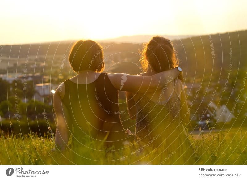 2 junge Frauen sitzen auf der Wiese und sehen in die Ferne Freizeit & Hobby Freiheit Sommer Mensch Erwachsene Geschwister Schwester Freundschaft Paar