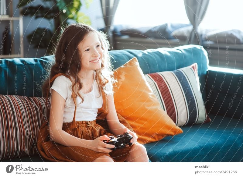 glückliches Kind beim Spielen von Videospielen mit Gamepad zu Hause Lifestyle Freude Freizeit & Hobby Wohnung Entertainment Erfolg Schulkind Computer