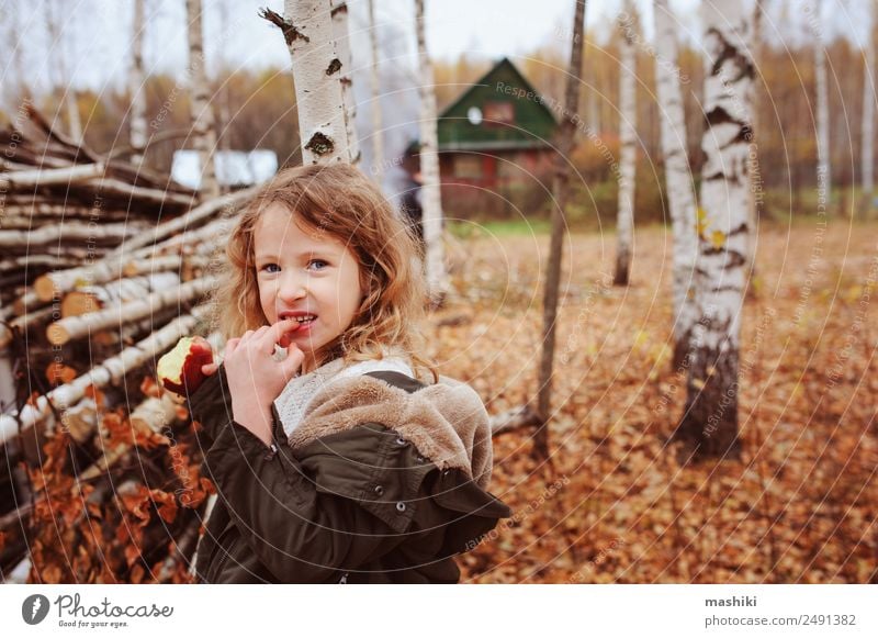 fröhlich lustiges Kind Mädchen isst frischen Apfel im Herbst Frucht Lifestyle Freude Glück Spielen stricken Garten Kindheit Natur Wärme Blatt Wald Schal Lächeln