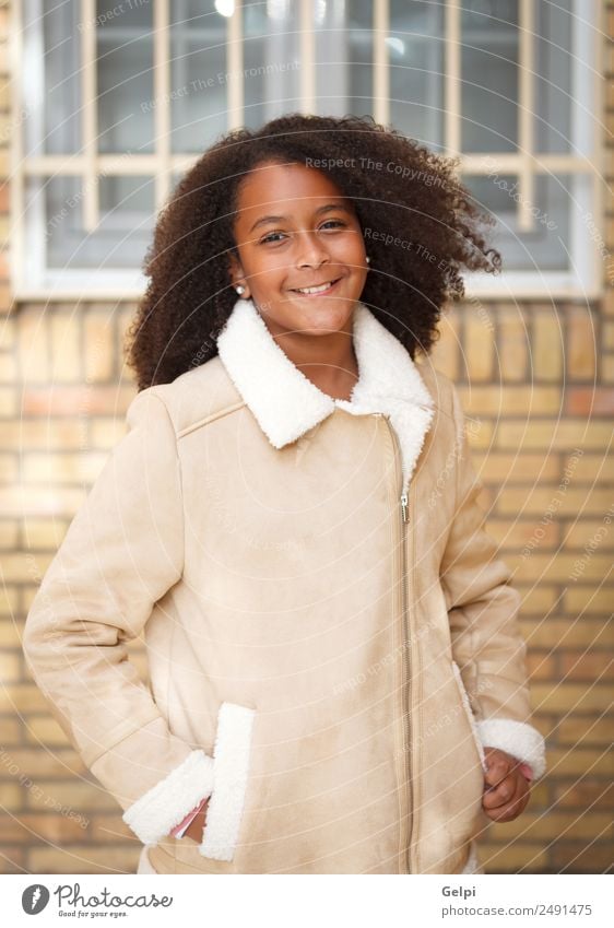 Hübsches Mädchen mit langem Afrohaar. Freude Glück schön Winter Kind Mensch Kleinkind Kindheit Natur Park Straße Afro-Look Lächeln Fröhlichkeit klein niedlich