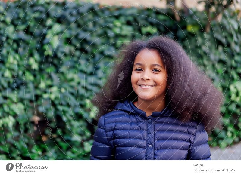 Hübsches Mädchen mit langem Afrohaar. Glück schön Gesicht Winter Garten Kind Mensch Frau Erwachsene Kindheit Park Mantel brünett Afro-Look Lächeln Fröhlichkeit