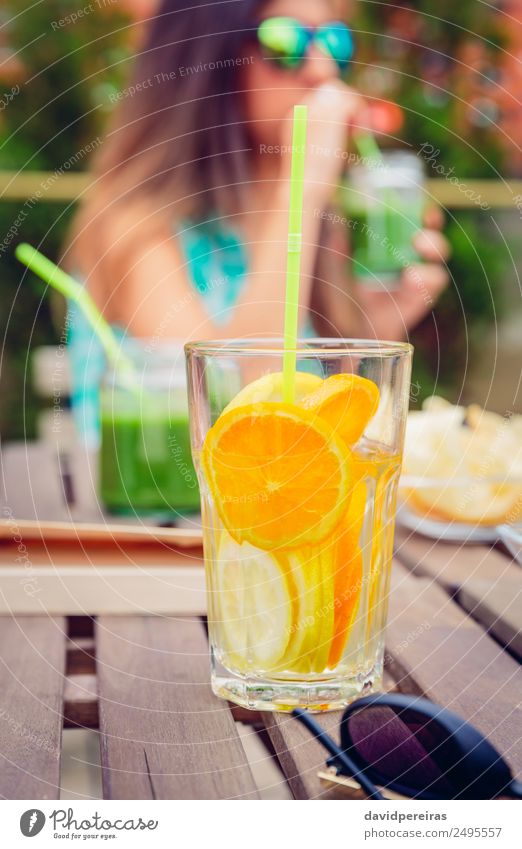 Aufgegossene Fruchtwasser-Cocktails und Frau, die grünen Smoothie trinkt. Gemüse Ernährung Diät Getränk Saft Tee Sommer Tisch Mensch Erwachsene Natur Holz