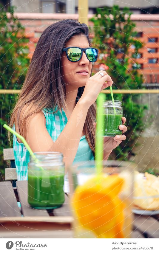 Frau mit Sonnenbrille, die im Freien grünen Gemüse-Smoothie trinkt. Frucht Ernährung Diät Getränk Saft Lifestyle Glück schön Sommer Mensch Erwachsene Natur