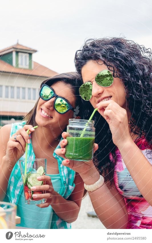 Zwei Frauen mit Sonnenbrille, die im Freien Bio-Getränke trinken. Gemüse Frucht Ernährung Diät Saft Lifestyle Glück Sommer Mensch Erwachsene Natur genießen