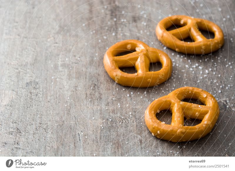 Gesalzene Brezeln auf Holzuntergrund Lebensmittel Brot Ernährung Mittagessen Vegetarische Ernährung Diät Oktoberfest braun Plätzchen Salz Foodfotografie