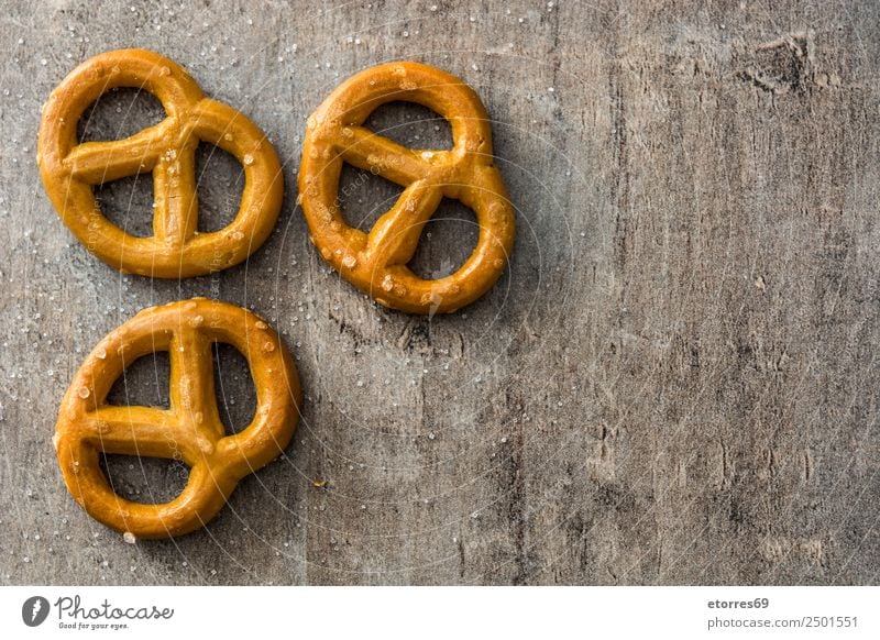 Gesalzene Brezeln auf Holzuntergrund Lebensmittel Brot Öl Ernährung Vegetarische Ernährung Diät Oktoberfest gut braun Laugenstange Salz Plätzchen Foodfotografie