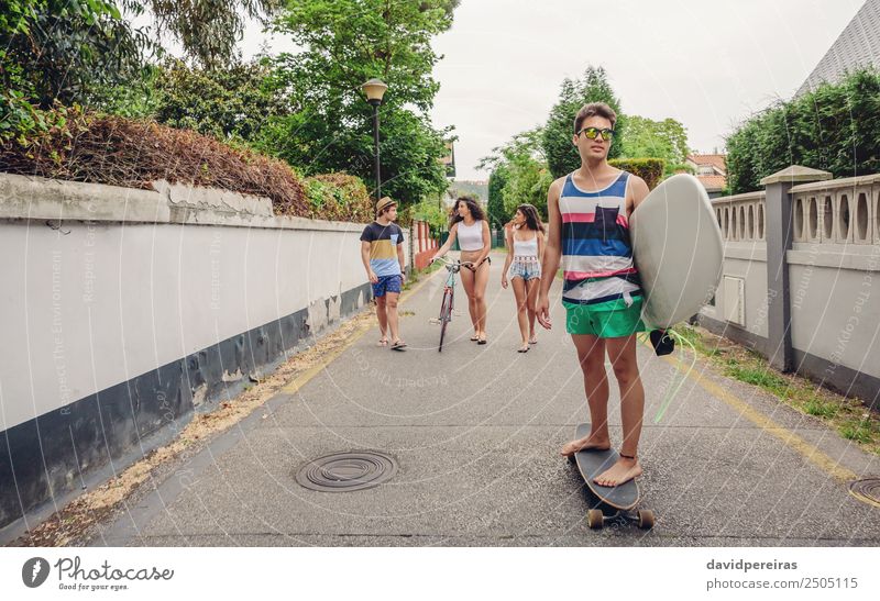 Junger Mann fährt auf dem Skate und hält Surfbrett. Lifestyle Freude Glück Freizeit & Hobby Sommer Strand Sport Frau Erwachsene Freundschaft Jugendliche