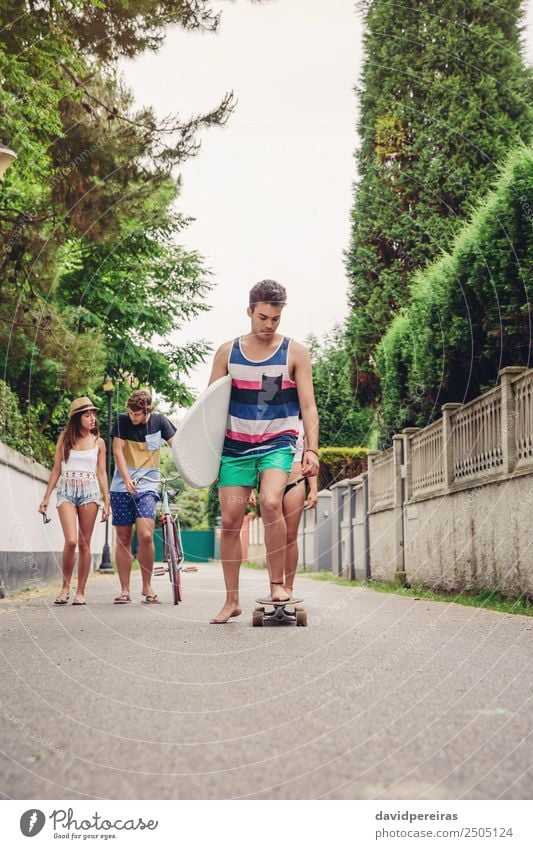 Junger Mann fährt auf dem Skate und hält Surfbrett. Lifestyle Freude Glück Freizeit & Hobby Sommer Strand Sport Frau Erwachsene Freundschaft Jugendliche