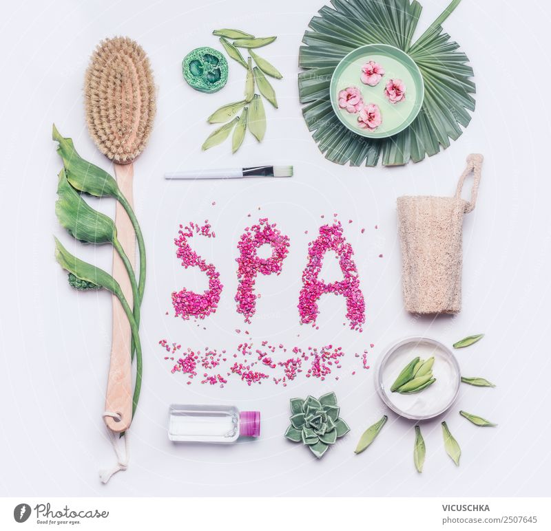 Spa- oder Wellness-Wohnung lag auf weißem Hintergrund. Werkzeuge zur Körperpflege und Cellulitebehandlung. Naturbürste für Peeling oder Massage der trockenen Haut, Creme und Luffaschwamm mit Blüten und tropischen Blättern, Draufsicht