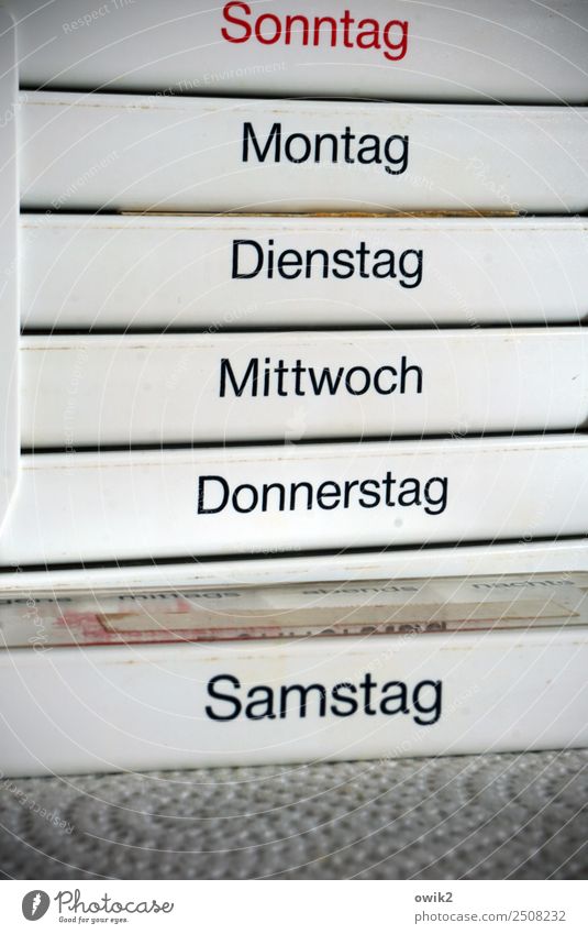 Pflegenotstand Medikament Schachtel Wochentag Kunststoff Schriftzeichen Fürsorge Gesundheitswesen Kontrolle Ordnung planen Vertrauen Farbfoto Gedeckte Farben