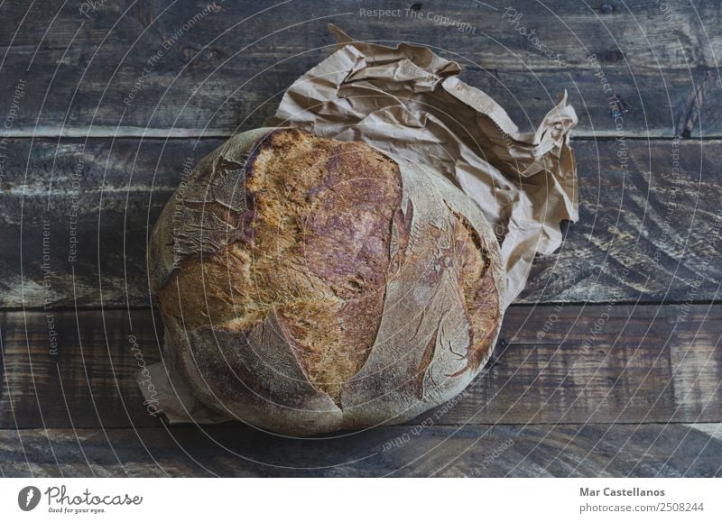 Laib rustikales Brot auf alten Holzbrettern Ernährung Pfanne Stil Gesunde Ernährung Tisch Kultur Dorf Papier schreiben lecker braun Handel Werbung Brotlaib