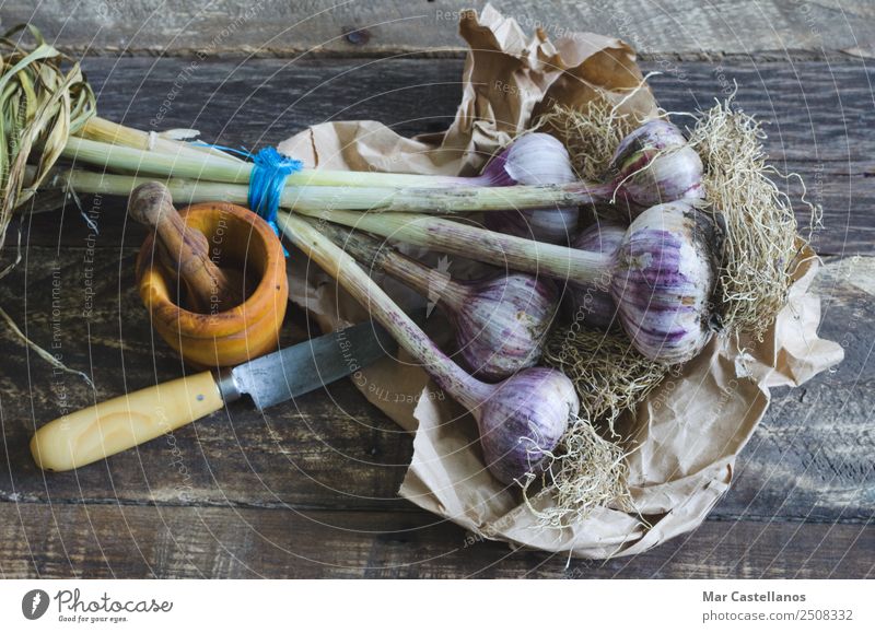 Knoblauchstrauß mit Geschirr auf Holzuntergrund Gemüse Kräuter & Gewürze Ernährung Essen Messer Küche Natur Pflanze Sommer Blatt Nutzpflanze füttern frisch