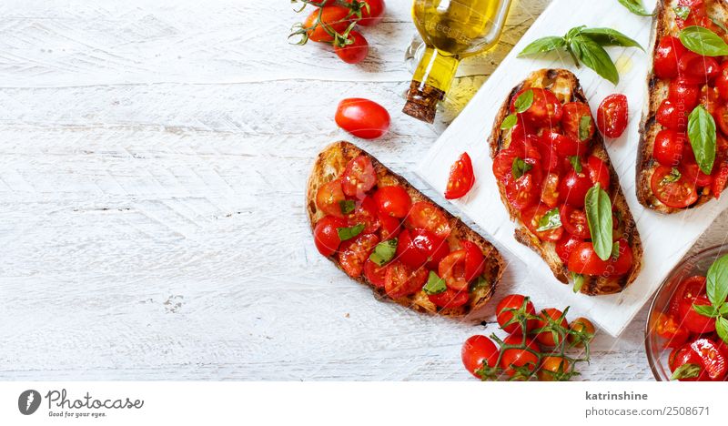 Hausgemachte italienische Bruschetta Gemüse Brot Ernährung Vegetarische Ernährung Diät Holz frisch lecker Tradition Antipasti Amuse-Gueule Baguette Basilikum