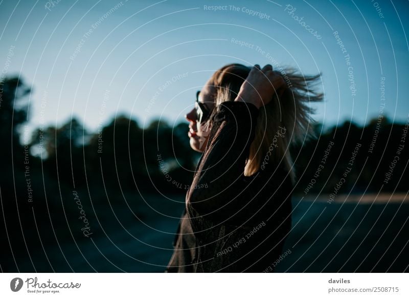 Blondes Mädchen mit Sonnenbrille posiert bei Sonnenuntergang mit einer Hand im Haar Lifestyle elegant Stil schön Mensch feminin Junge Frau Jugendliche 1