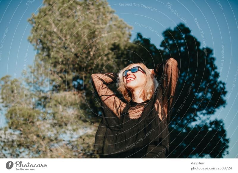 Blonde Frau in schwarzem Kleid, die sich bei Sonnenuntergang in der Natur vergnügt. Lifestyle Reichtum elegant Freude schön Wellness Leben Mensch Junge Frau