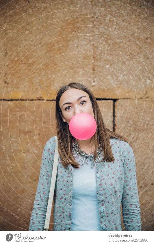 Junges Teenagermädchen, das rosa Kaugummi bläst. Lifestyle Freude Glück schön Gesicht Mensch Frau Erwachsene Jugendliche Mund Lippen Mode brünett Luftballon