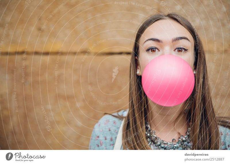 Junges Teenagermädchen, das rosa Kaugummi bläst. Lifestyle Freude Glück schön Gesicht Mensch Frau Erwachsene Jugendliche Mund Lippen Mode brünett Luftballon