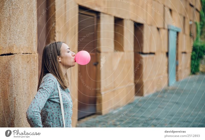 Junges Teenagermädchen, das rosa Kaugummi bläst. Lifestyle Freude Glück schön Gesicht Mensch Frau Erwachsene Jugendliche Mund Lippen Mode brünett Luftballon