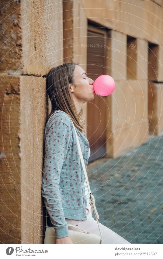 Junges Teenagermädchen, das rosa Kaugummi bläst. Lifestyle Freude Glück schön Gesicht ruhig Mensch Frau Erwachsene Jugendliche Mund Lippen Mode brünett